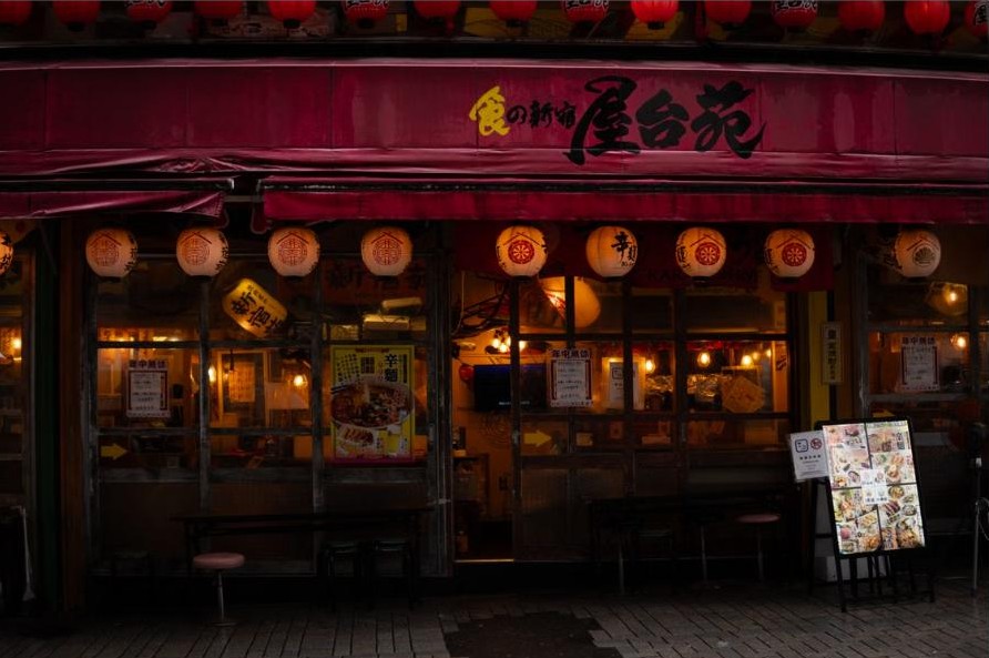 Traditional izakaya storefront with red lanterns lit up at night in Japan