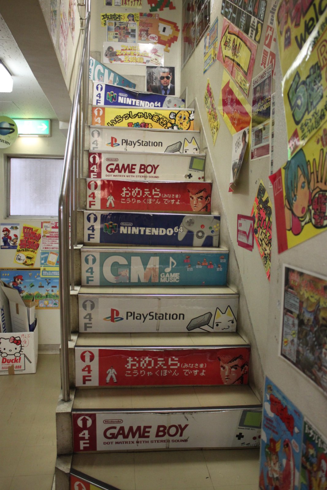 Interior stairwell decorated with retro game signage at Super Potato