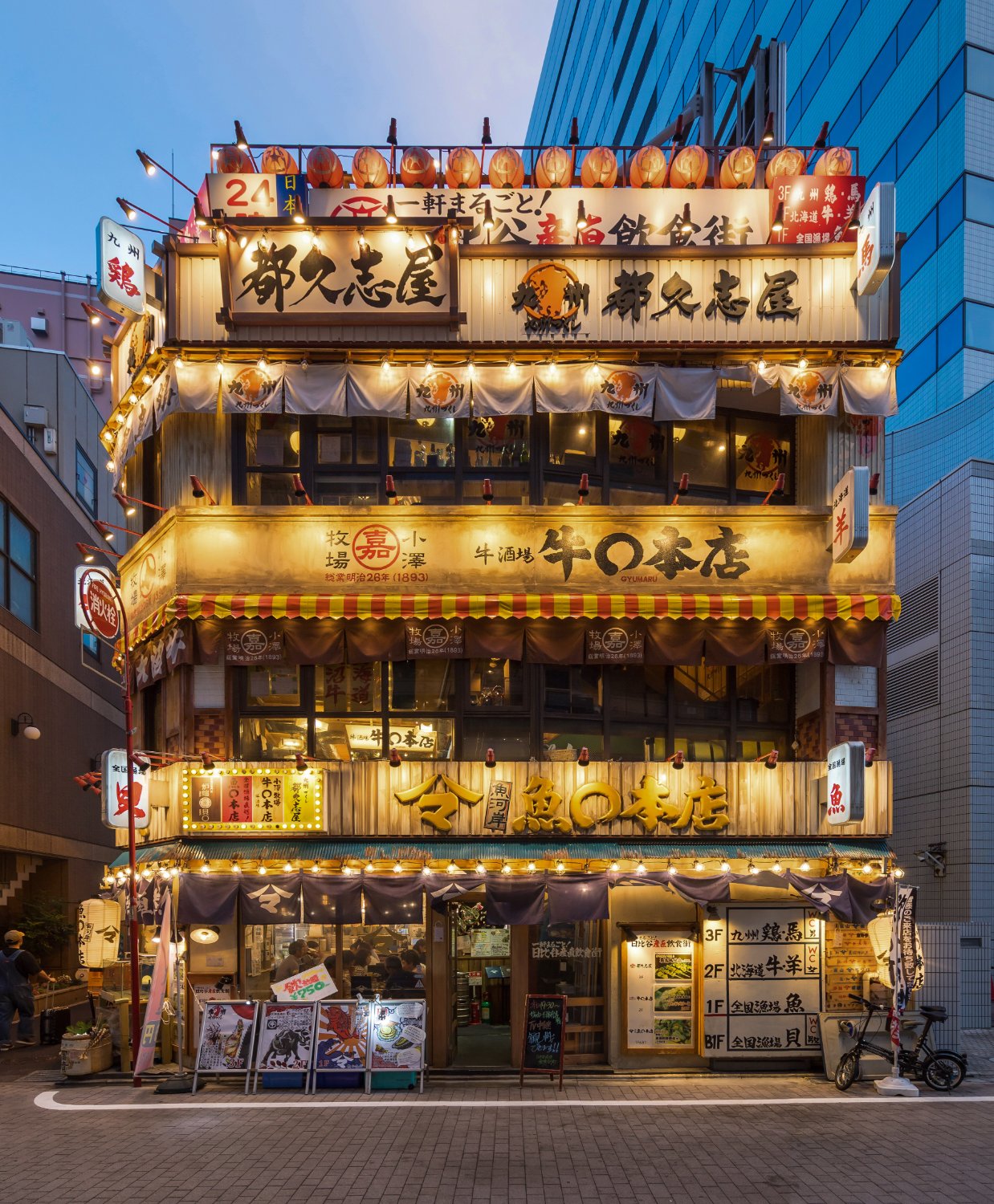 Illuminated izakaya facade with red paper lanterns in Chiyoda, Tokyo